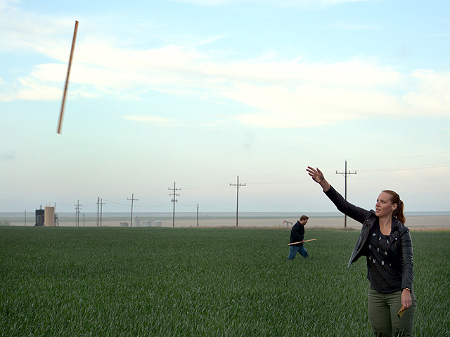 Tour leaders instructed scouts to throw yardsticks into each field to select random spots to estimate yields. International Trade Specialist for USDA/FAS Christine Mumma, tosses her yardstick into a field early Wednesday morning near Russell Springs, Kansas. (DTN photo by Rhonda Brooks)